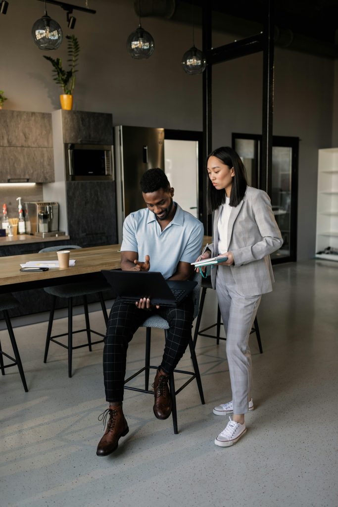 Two professionals engaged in a business discussion in a stylish, contemporary office setting.